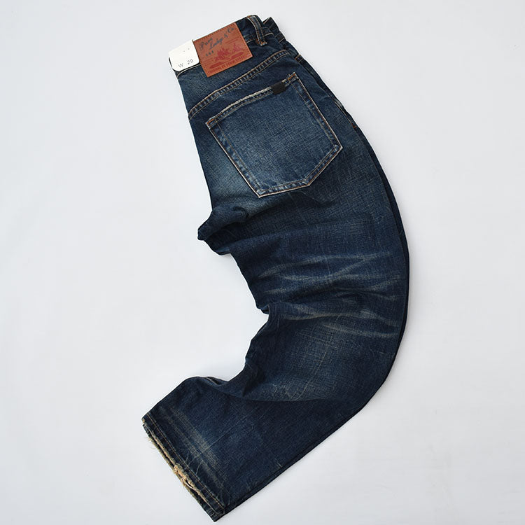 Straight denim pants with whiskered and distressed hem